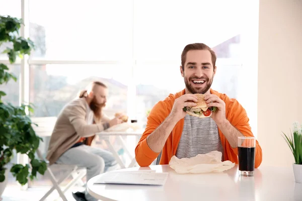 Emotionele Bebaarde Man Met Lekker Hamburger Tegen Een Achtergrond Met — Stockfoto