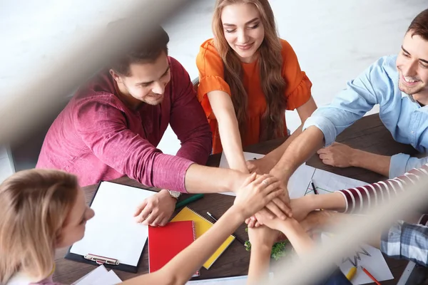 Jóvenes Poniendo Manos Juntas Mientras Trabajan Proyectos Interiores Concepto Unidad — Foto de Stock