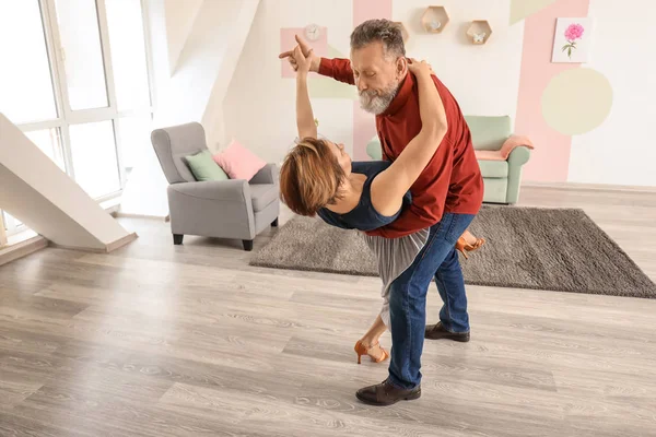 Happy mature couple dancing at home