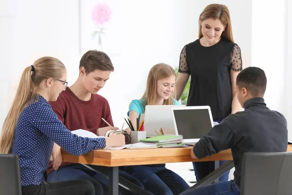 Grupo Adolescentes Haciendo Tarea Con Profesor Aula — Foto de Stock