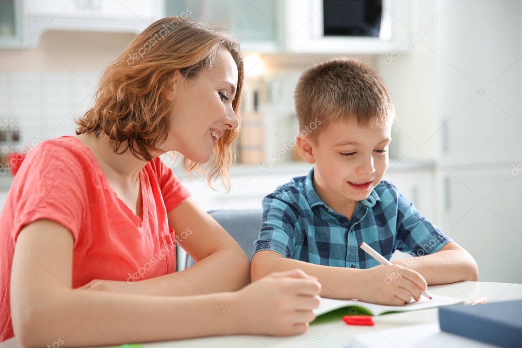 Little boy with mother doing homework at home