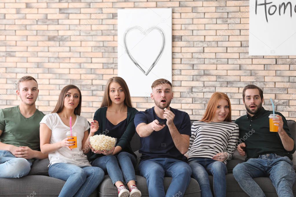 Young people watching TV at home