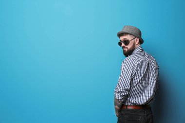 Renk arka plan üzerinde şık kıyafeti yakışıklı hipster portresi