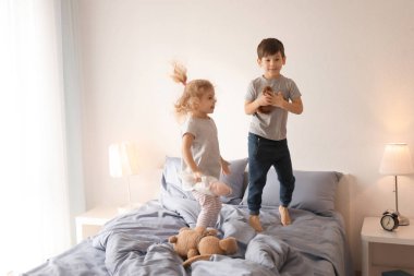Sevimli kız babasıyla yatakta evde oynarken
