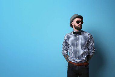 Renk arka plan üzerinde şık kıyafeti yakışıklı hipster portresi