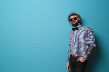 Renk arka plan üzerinde şık kıyafeti yakışıklı hipster portresi