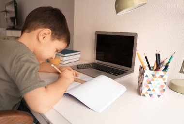 Sevimli küçük çocuk çok ödevim ile kitaplığında yapmak