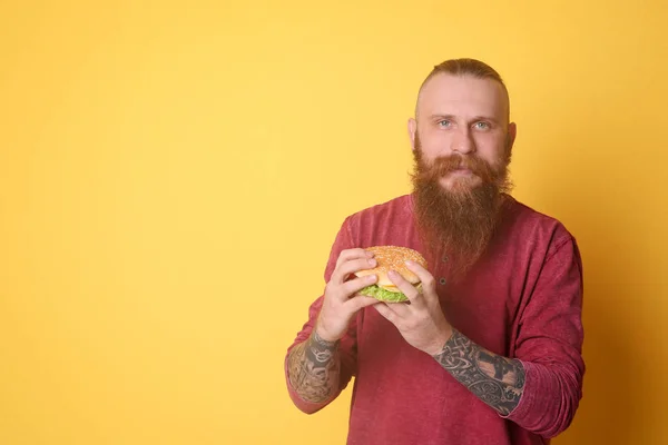 Bärtiger Mann Mit Leckerem Burger Vor Farbigem Hintergrund — Stockfoto