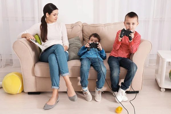 Lindos Niños Pequeños Jugando Videojuegos Mientras Niñera Está Leyendo Revista — Foto de Stock