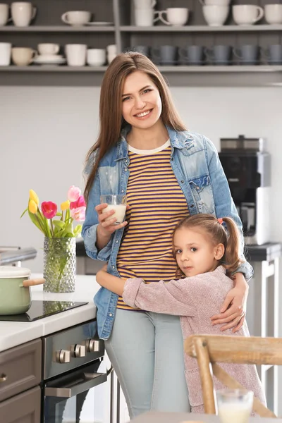 可爱的小女孩的肖像拥抱她的母亲在厨房里 — 图库照片