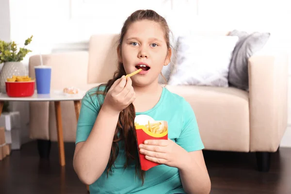 Överviktig Flicka Äter Pommes Frites Inomhus — Stockfoto