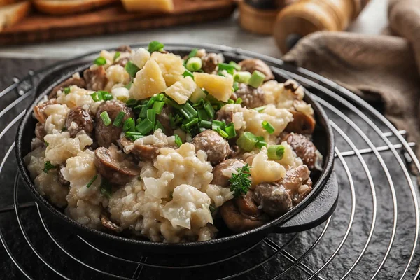 Dish with risotto and mushrooms on table