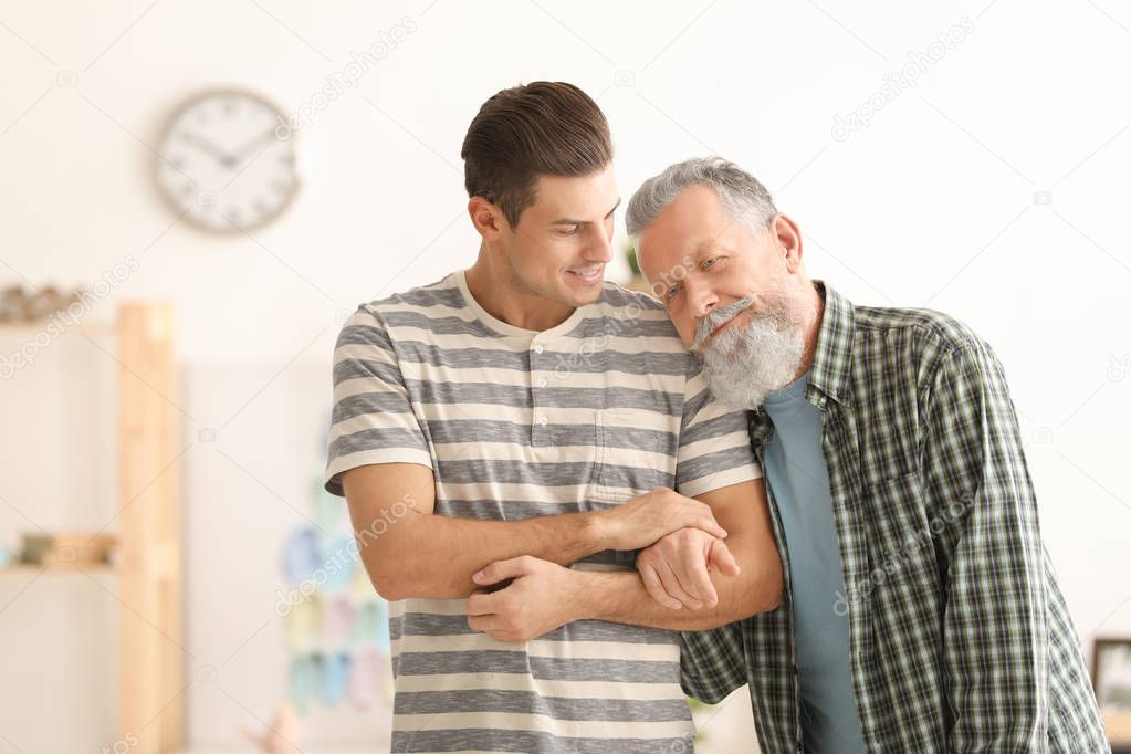Senior man with young caregiver at home