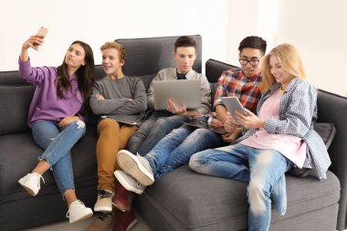Genç modern cihazlar kapalı kanepede otururken selfie alarak ile grup