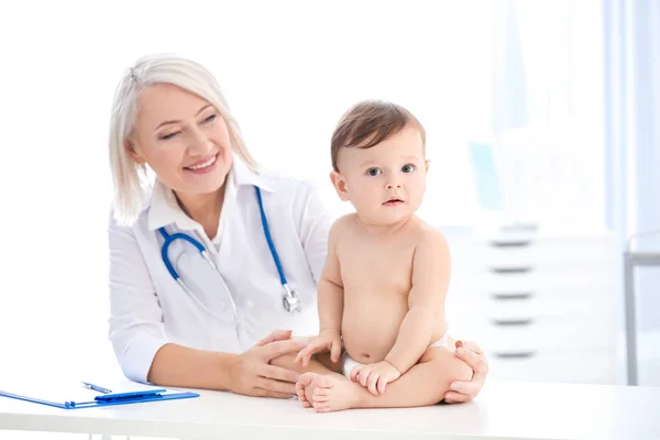 成熟的女医生与可爱的男婴在诊所 — 图库照片