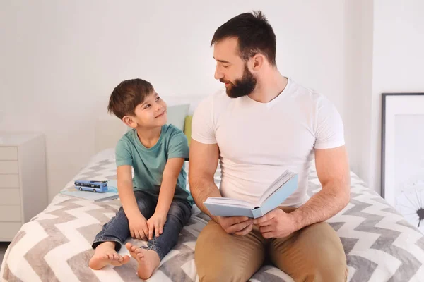 父亲读书给他的小儿子在家里 — 图库照片