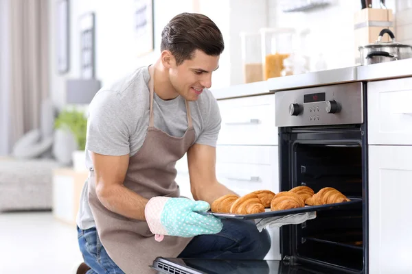 Man Taking Baking Tray Delicious Croissants Out Electric Oven Kitchen — Stock Photo, Image