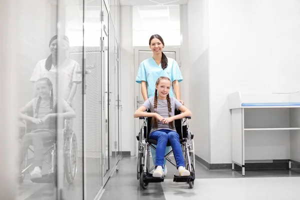 若い女医は 室内での車椅子の人の世話 — ストック写真