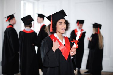 Mutlu Öğrenci Lisans elbise kapalı diploması ile içinde. Mezuniyet günü