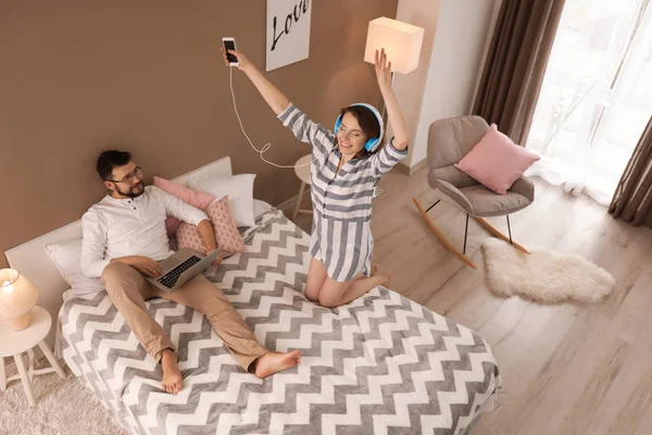 Прекрасна Пара Вдома Жінка Танцює Навушниками Чоловік Лежить Ліжку — стокове фото