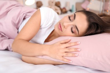 Evdeki yatakta uyuyan güzel bir genç kadın.