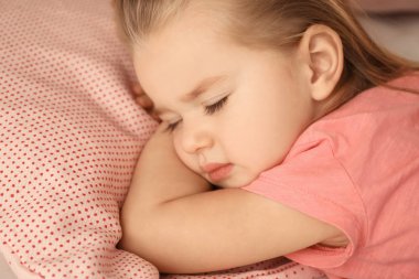 Evdeki yatakta uyuyan tatlı küçük kız.