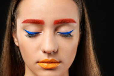 Genç ve kadın ile boyalı kaşlar siyah arka plan, closeup yaratıcı makyaj