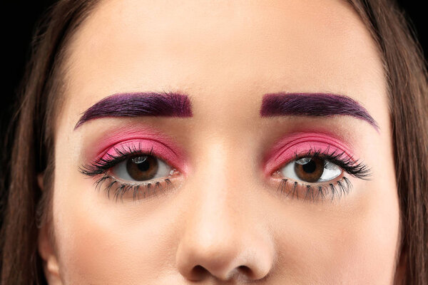 Young woman with dyed eyebrows and creative makeup, closeup