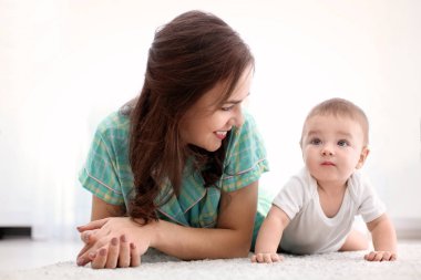 Sevgi dolu bir anne ve bebeği yerde evde yatarken