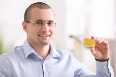 Kontakt lens durumda tutarak gözlüklü genç adam arka plan bulanık