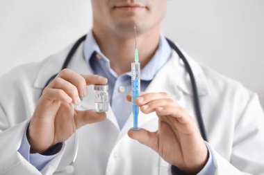 Doctor with syringe and vial, closeup. Vaccination day clipart