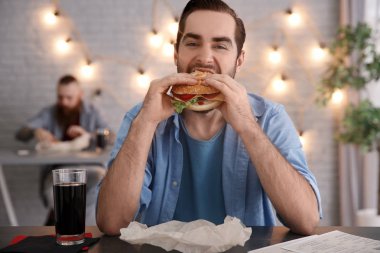Man kafede lezzetli hamburger yemek