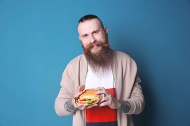 Lezzetli burger renkli arka plan ile sakallı adam