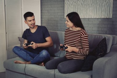 Evde video oyunu oynayan genç çift
