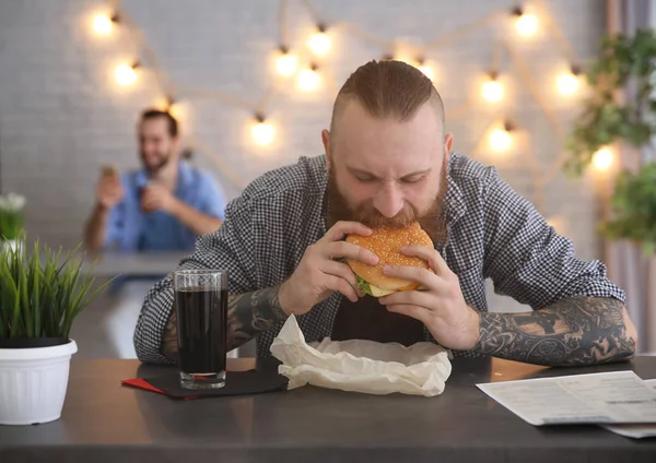 Szakállas Ember Eszik Finom Hamburgert Kávézó — Stock Fotó