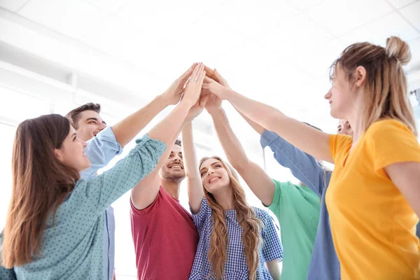 Jóvenes Poniendo Las Manos Juntas Sobre Fondo Claro Concepto Unidad — Foto de Stock