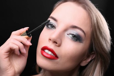 Güzel genç kadın kirpik uzantıları üzerinde koyu arka plan, closeup ile portresi