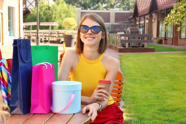 Mooie Vrouw Met Boodschappentassen Zittend Aan Tafel Buiten — Stockfoto