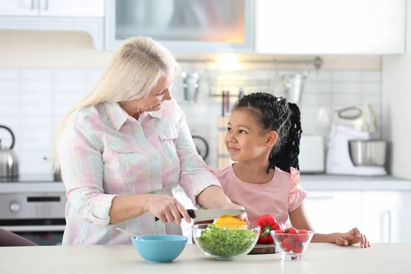 Female Mature Nanny Teaching Little African American Girl Cut Vegetables — Stock Photo, Image