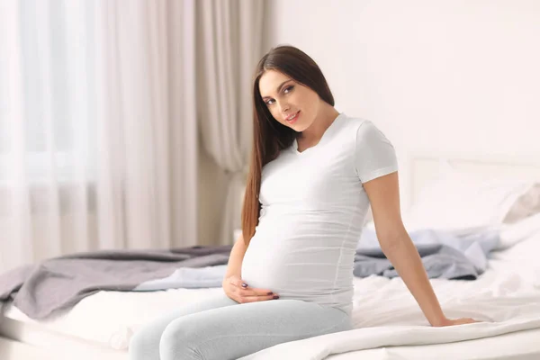 自宅のベッドで休んで美しい妊娠中の女性の肖像画 — ストック写真