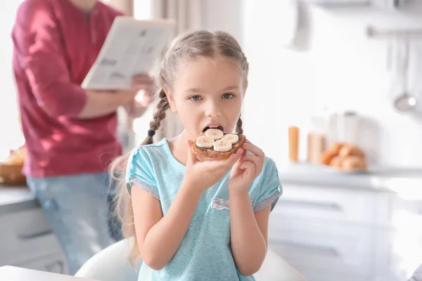 Menina Comendo Torrada Saborosa Com Banana Pasta Chocolate Dentro Casa — Fotografia de Stock