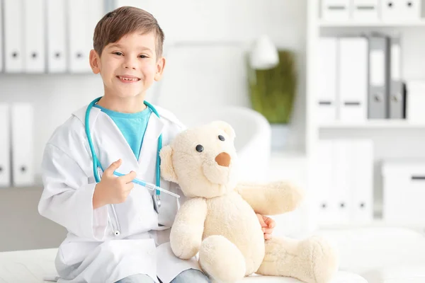可爱的小男孩打扮成医生在医院玩玩具熊 — 图库照片