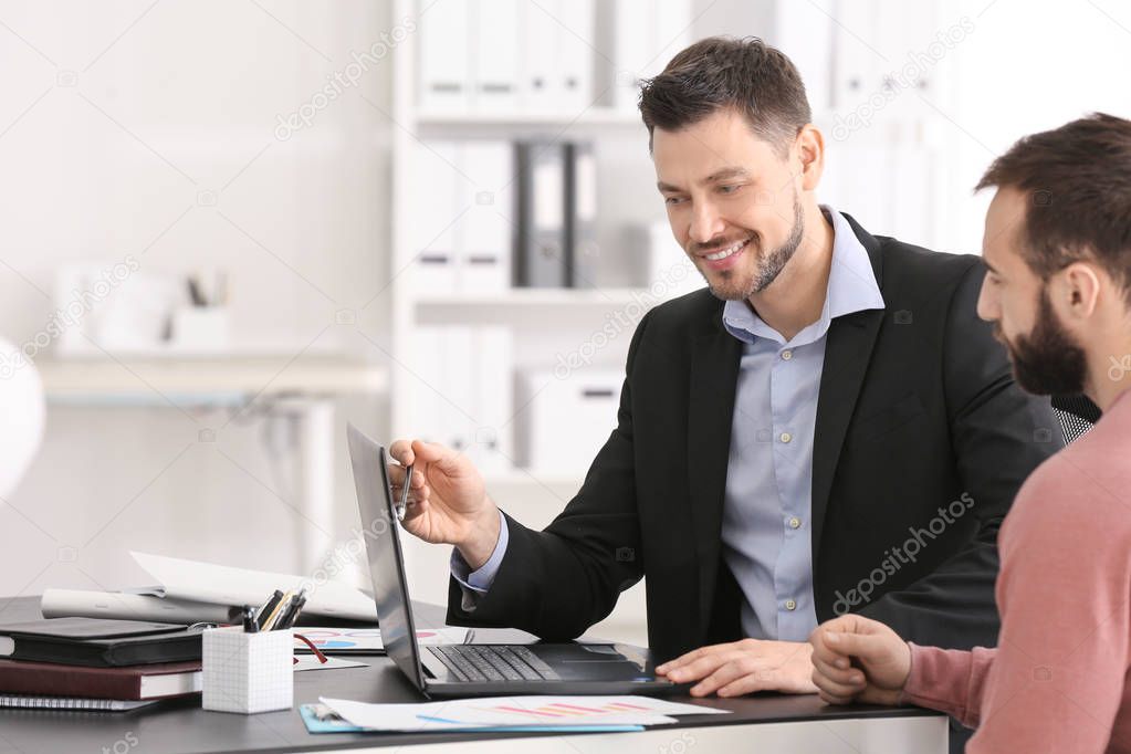 Businessman consulting young man in office