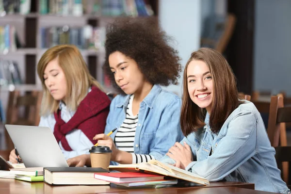Group of students studying at table in library — Stock Photo, Image