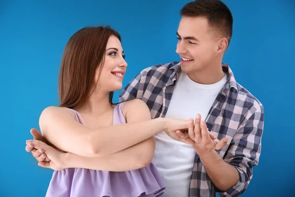 Pareja joven bailando juntos sobre fondo de color —  Fotos de Stock