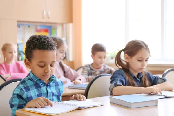 Lindos niños haciendo deberes en el aula en la escuela — Foto de Stock