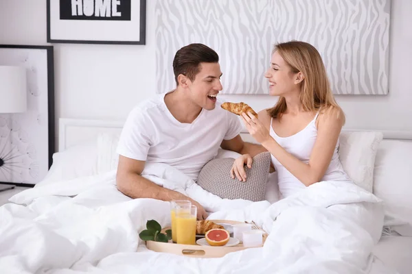 Gelukkig paar ontbijten samen in bed — Stockfoto