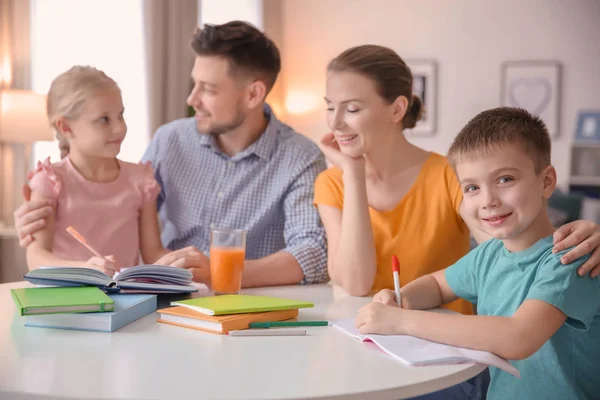 Små barn med föräldrar gör läxor hemma — Stockfoto