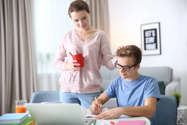 Teenager mit Mutter bei Hausaufgaben zu Hause — Stockfoto