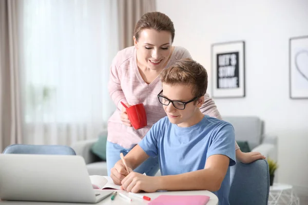 Adolescente con madre haciendo deberes en casa —  Fotos de Stock